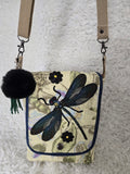 Medium size purse quilted with embroidered dragonfly. On the front with 2 pockets, 1 inside 1 outside yellows and greens and blues. 10x14 crossbody