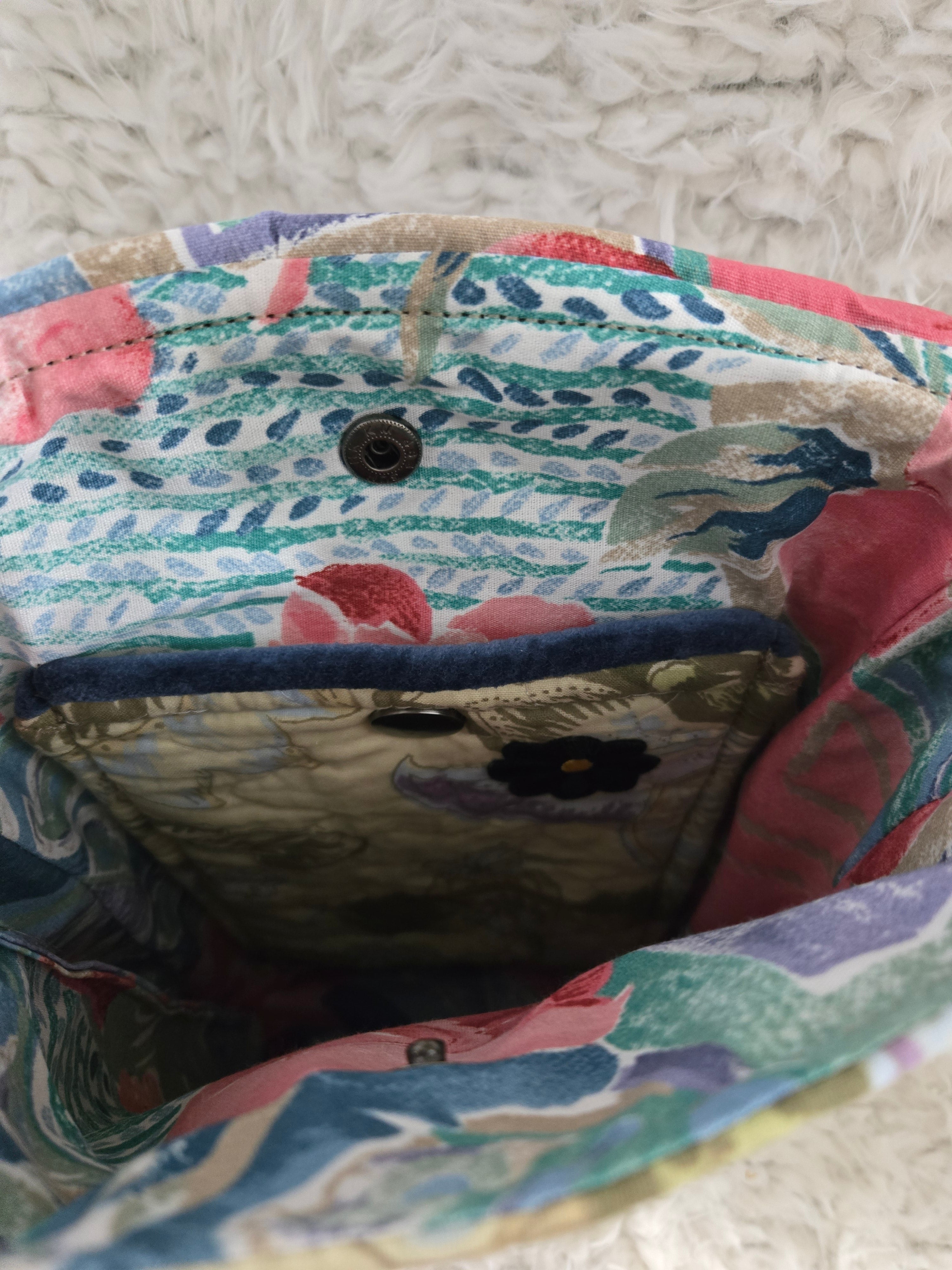 Medium size purse quilted with embroidered dragonfly. On the front with 2 pockets, 1 inside 1 outside yellows and greens and blues. 10x14 crossbody
