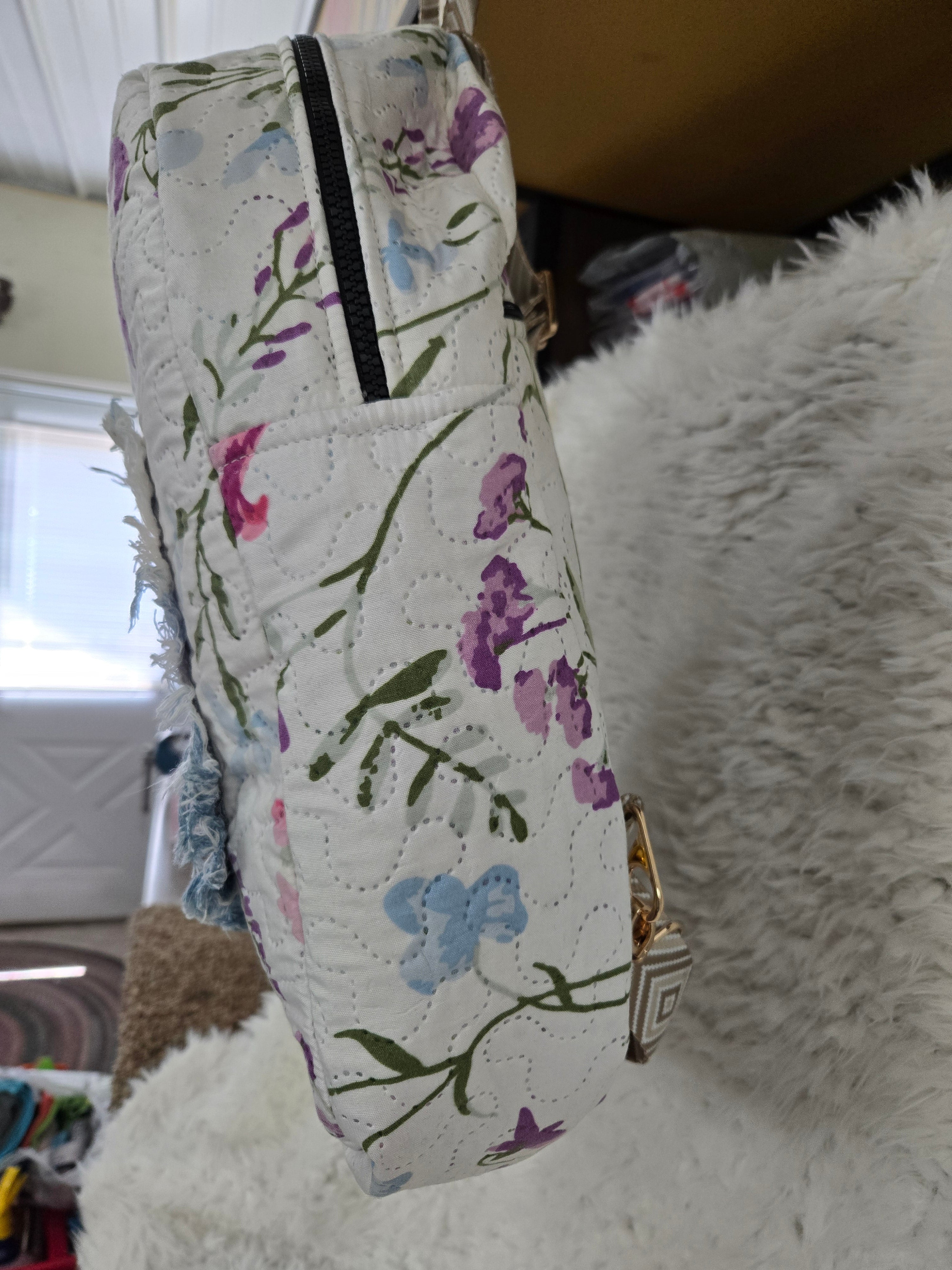 Large backpack made from quilt, has butterfly on the front, two zipper pockets in the back and one pocket on the inside with the key ring
