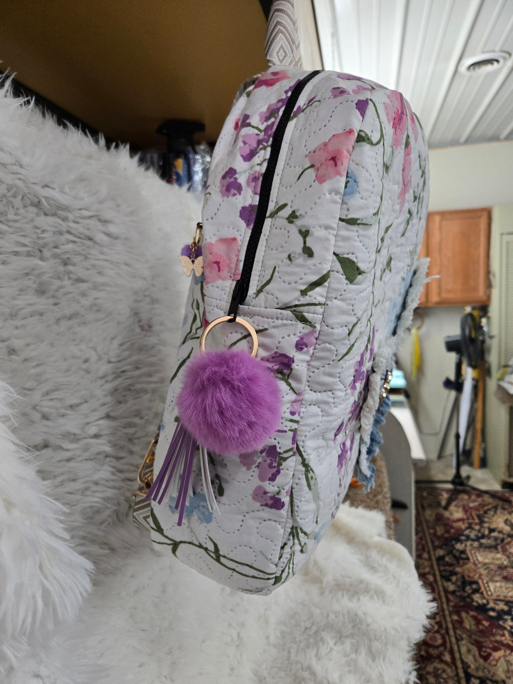 Large backpack made from quilt, has butterfly on the front, two zipper pockets in the back and one pocket on the inside with the key ring