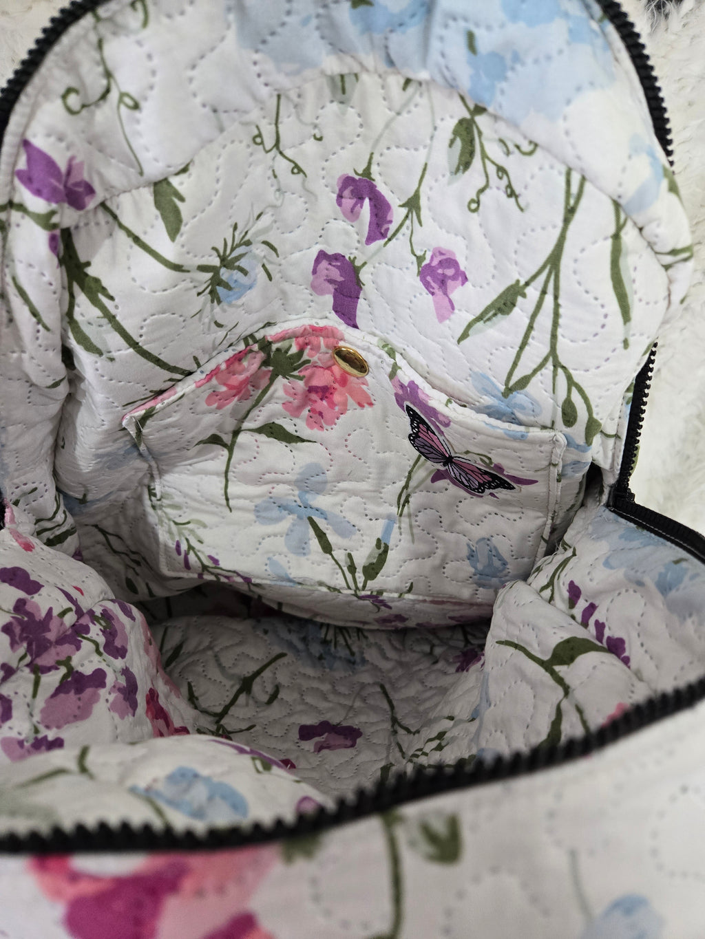 Large backpack made from quilt, has butterfly on the front, two zipper pockets in the back and one pocket on the inside with the key ring