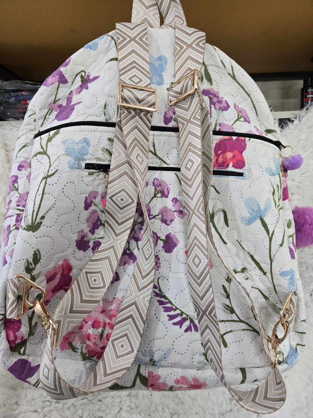 Large backpack made from quilt, has butterfly on the front, two zipper pockets in the back and one pocket on the inside with the key ring